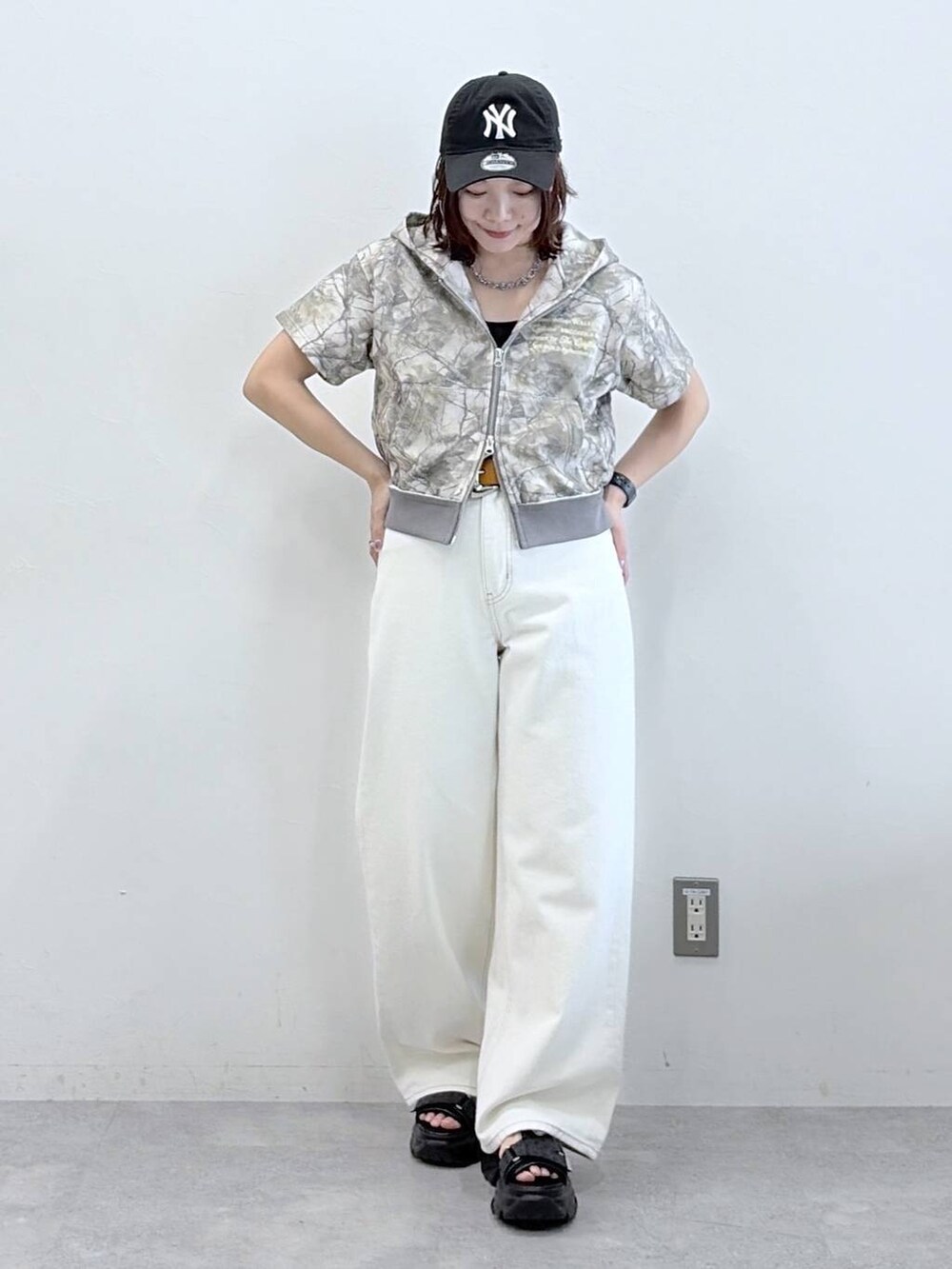 ホワイト系のデニムパンツ、ブラック系のサンダル、その他のパーカーを着用したレディースの春コーディネートの8枚目の写真