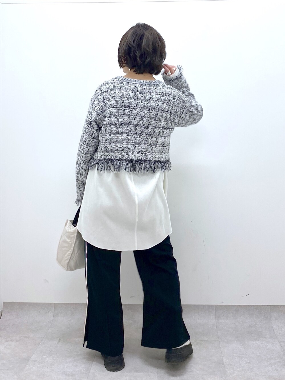 ホワイト系のニット/セーター、ブラック系のスウェットパンツ、ホワイト系のシューズを着用したレディースの春コーディネートの4枚目の写真