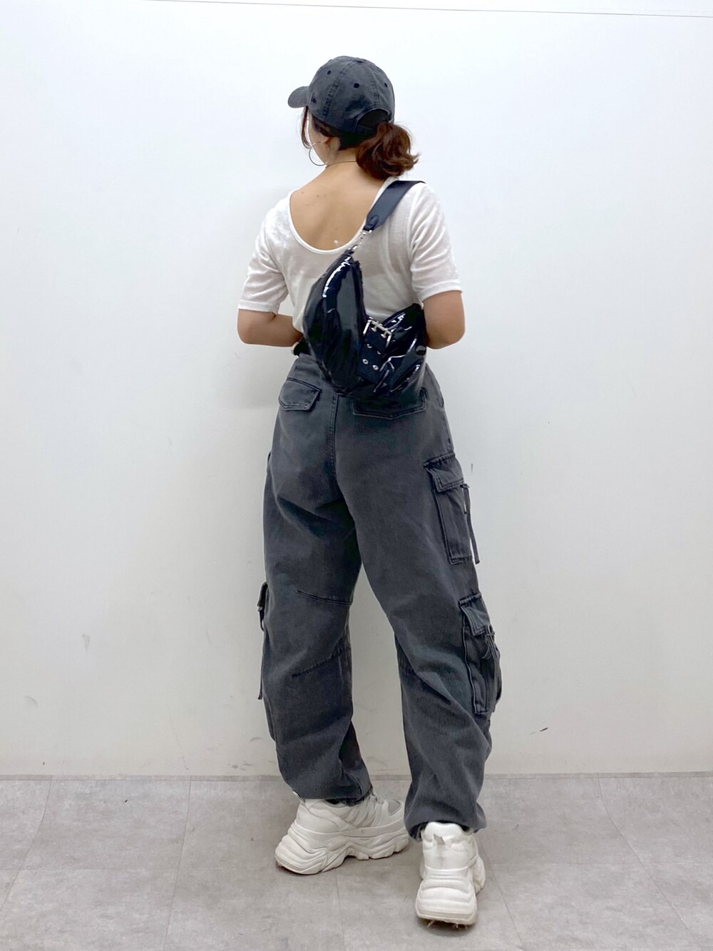 ブラック系のデニムパンツ、ホワイト系のスニーカー、ブラック系のショルダーバッグを着用したレディースの夏コーディネートの7枚目の写真