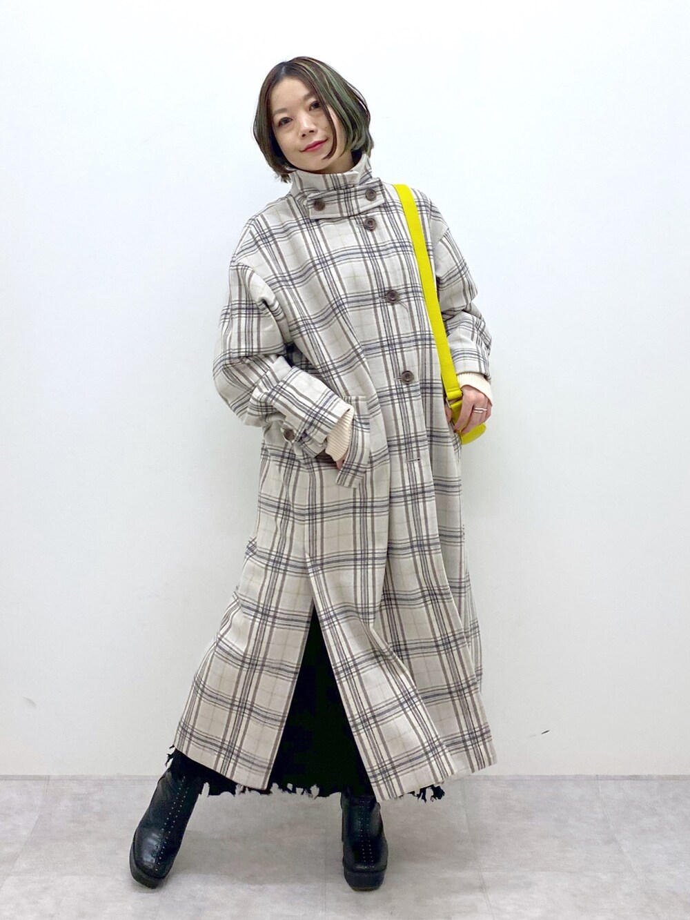 ホワイト系のジャケット/アウター、ブラック系のブーツ、ブラック系のスカートを着用したレディースの冬コーディネートの5枚目の写真