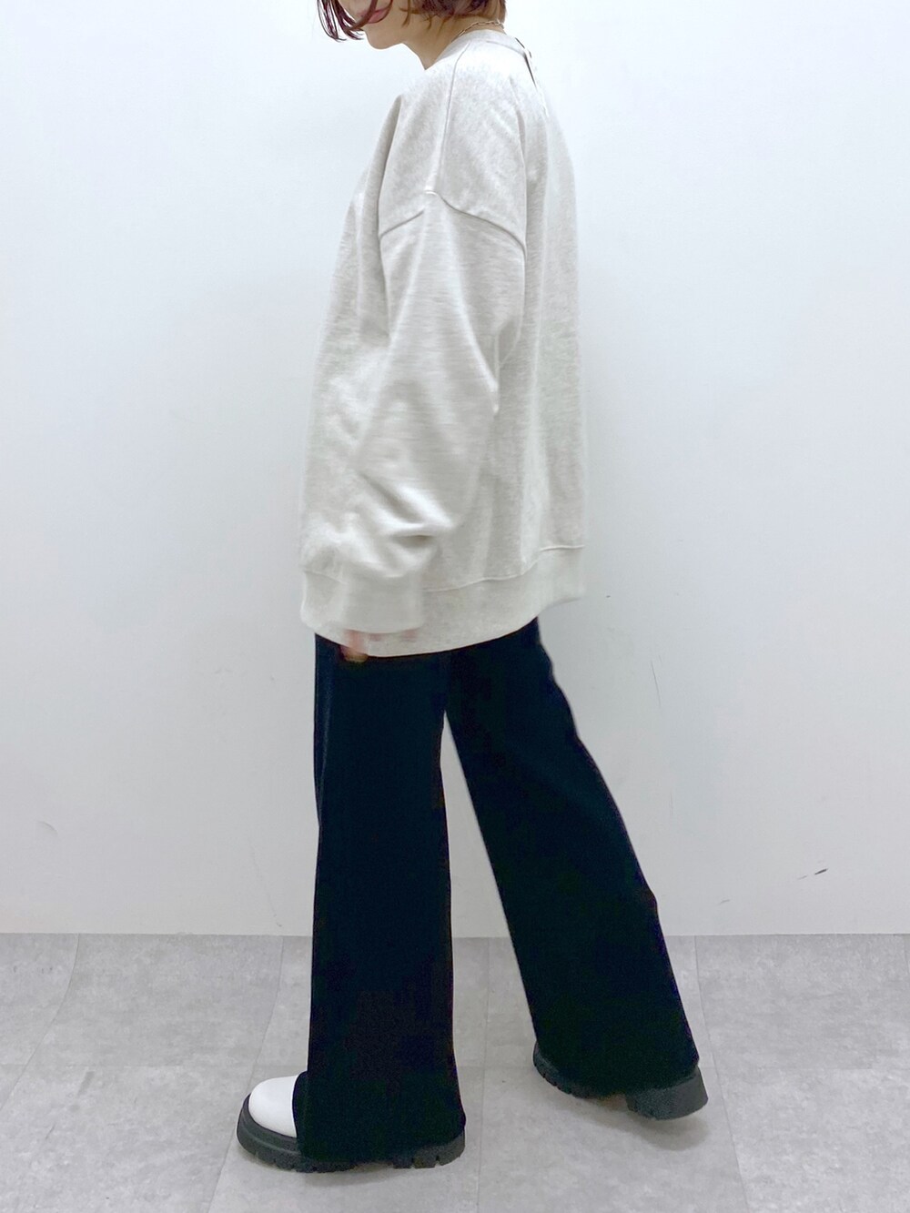 ベージュ系のトップス、ブラック系のパンツ、ホワイト系のシューズを着用したレディースの秋コーディネートの4枚目の写真