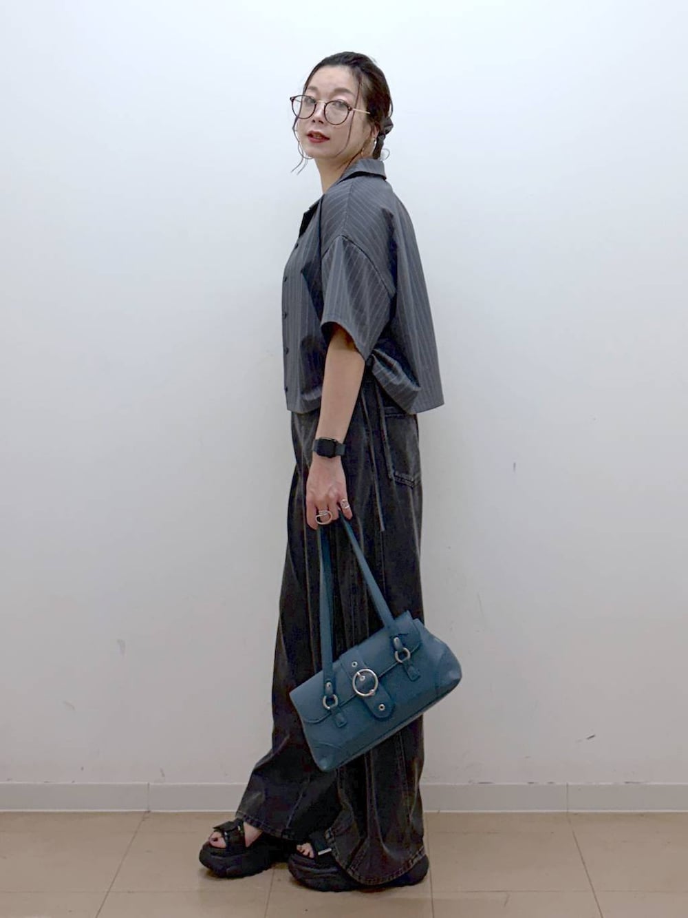 ブラック系のデニムパンツ、ブラック系のサンダル、グレー系のシャツ/ブラウスを着用したレディースの夏コーディネートの5枚目の写真