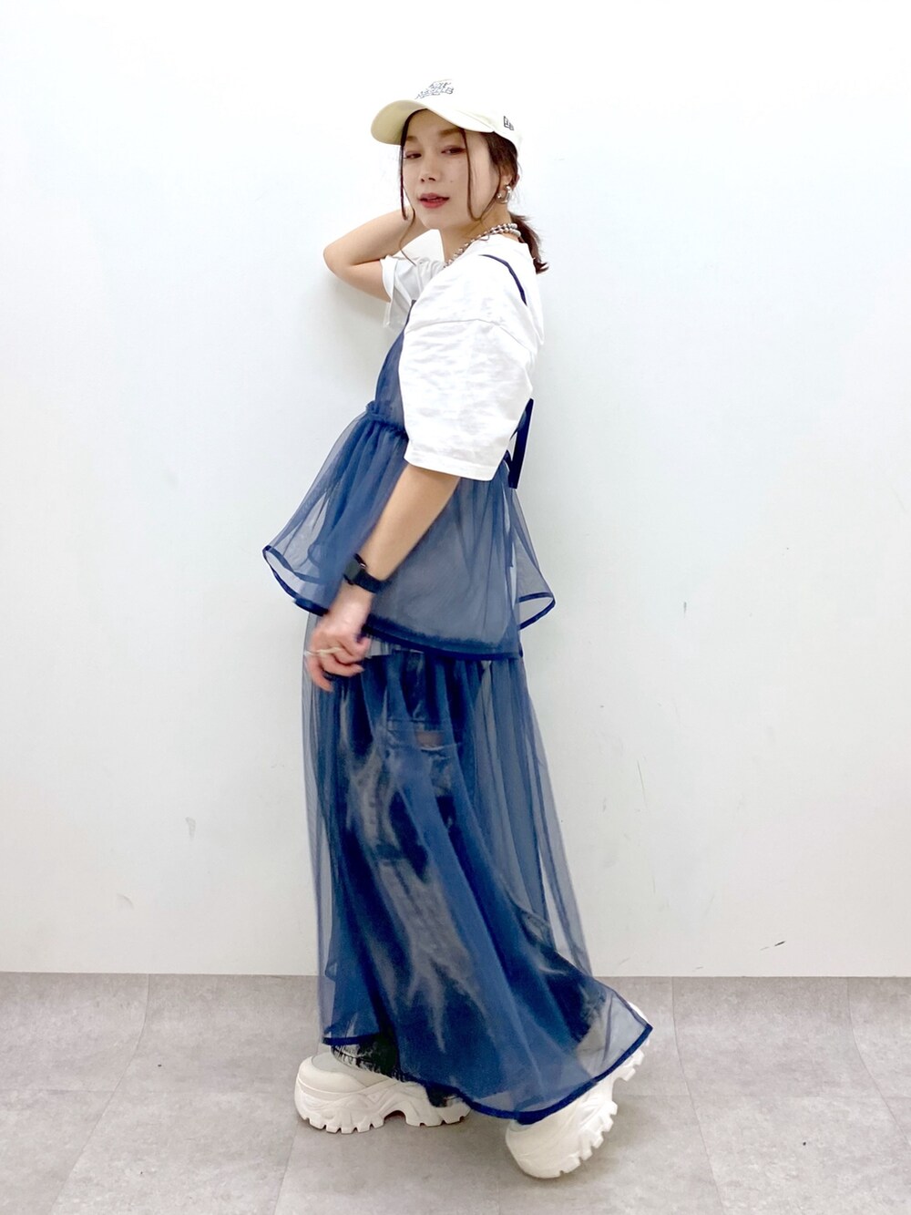 ホワイト系のTシャツ/カットソー、ブルー系のワンピース、ブラック系のデニムパンツを着用したレディースの春コーディネートの4枚目の写真