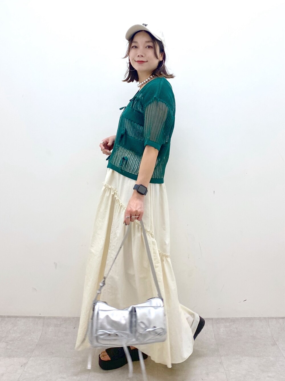 ホワイト系のスカート、グレー系のタンクトップ、シルバー系のショルダーバッグを着用したレディースの夏コーディネートの8枚目の写真