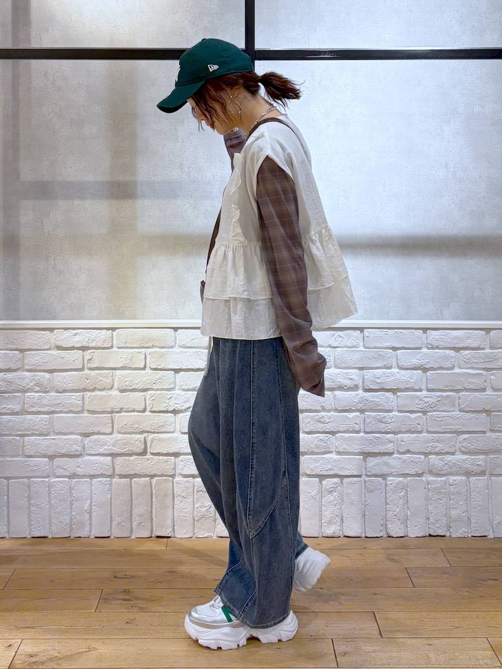 ホワイト系のスニーカー、ブラウン系のショルダーバッグ、ブルー系のデニムパンツを着用したレディースの春コーディネートの7枚目の写真