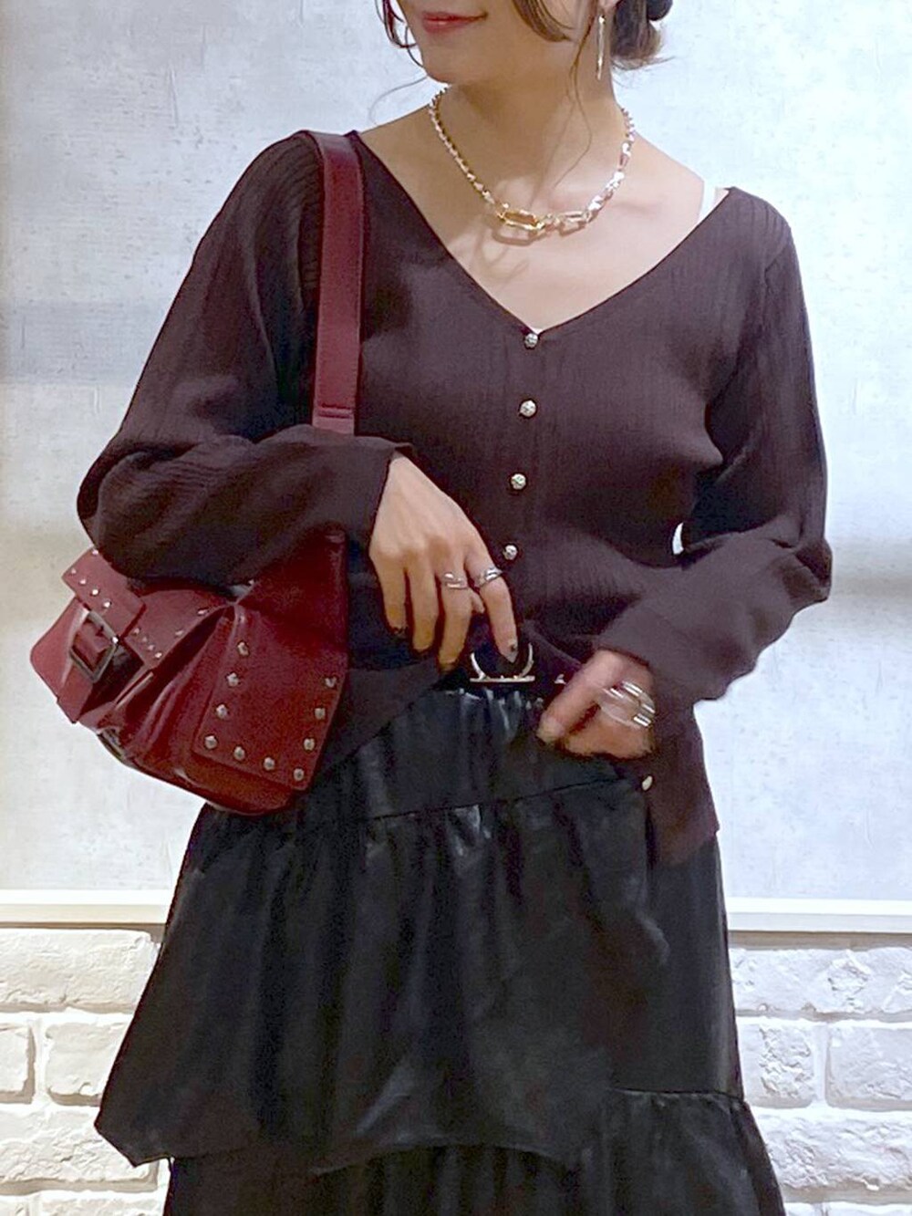 ホワイト系のパンプス、レッド系のショルダーバッグ、ブラック系のスカートを着用したレディースの夏コーディネートの2枚目の写真