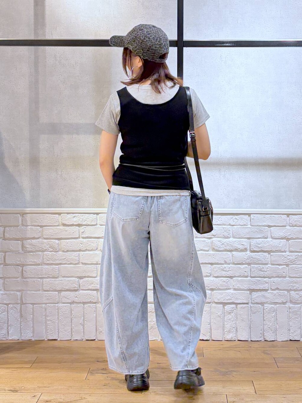 ブルー系のデニムパンツ、ブラック系のショルダーバッグ、ブラック系のサンダルを着用したレディースの春コーディネートの7枚目の写真
