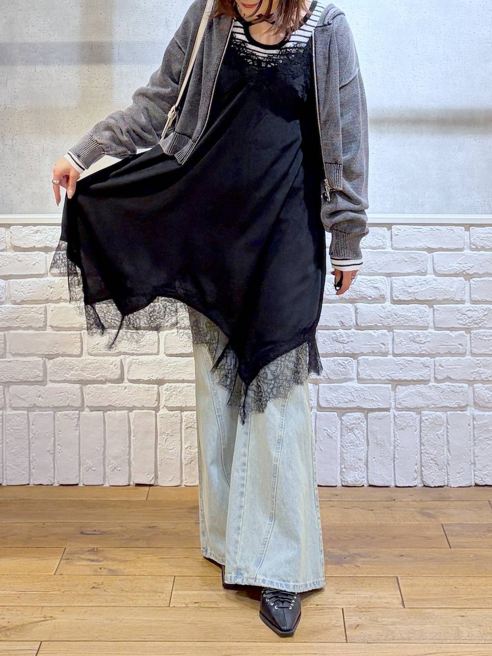 ブルー系のデニムパンツ、ホワイト系のボストンバッグ、ホワイト系のニット/セーターを着用したレディースの春コーディネートの3枚目の写真