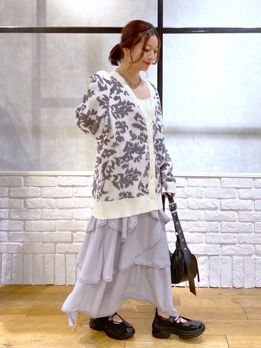 ブラック系のショルダーバッグ、ホワイト系のカーディガン/ボレロ、ホワイト系のキャミソールを着用したレディースの春コーディネートの8枚目の写真