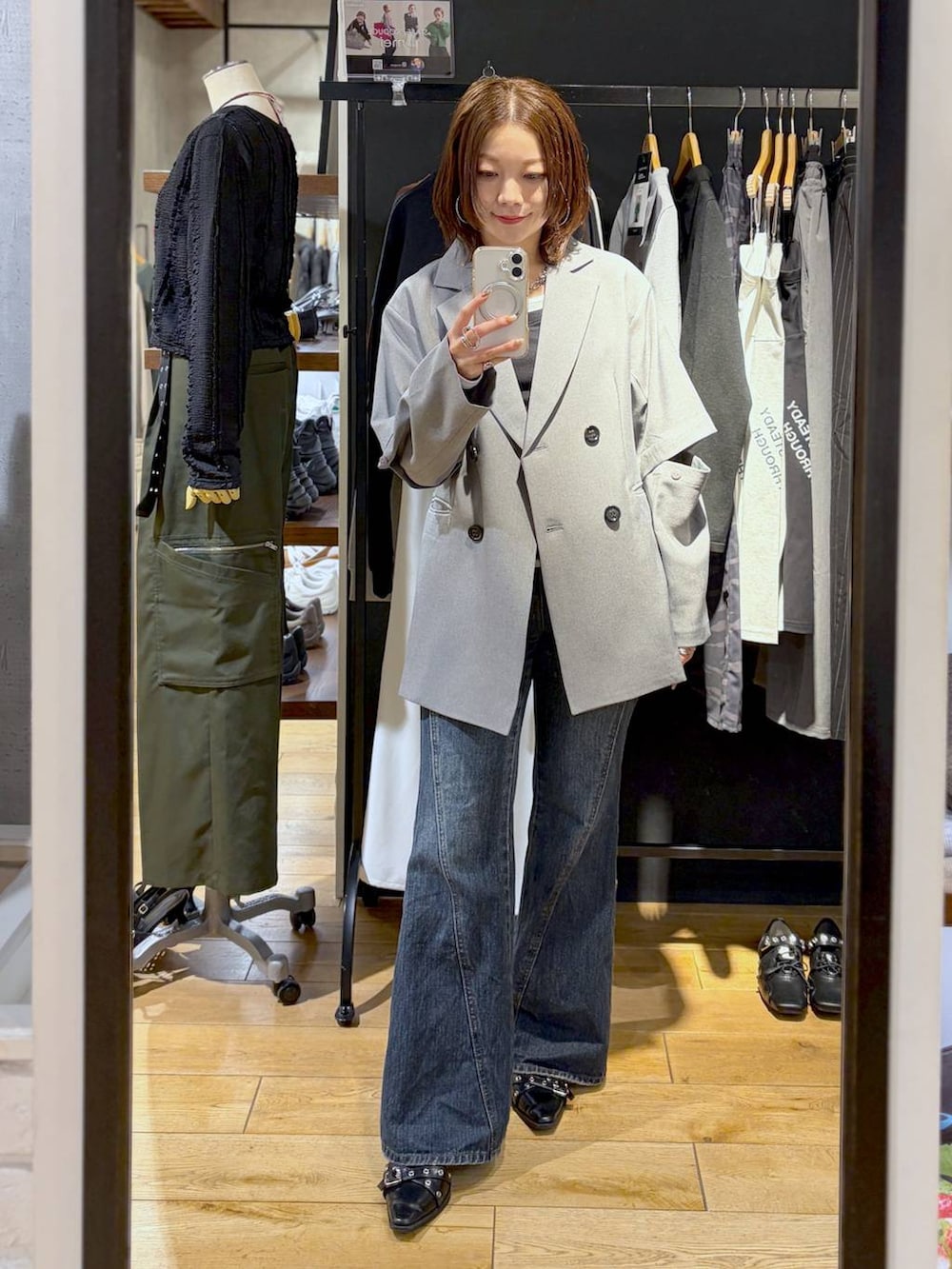 ブルー系のデニムパンツ、グレー系のテーラードジャケット、ブラック系のTシャツ/カットソーを着用したレディースの春コーディネートの2枚目の写真