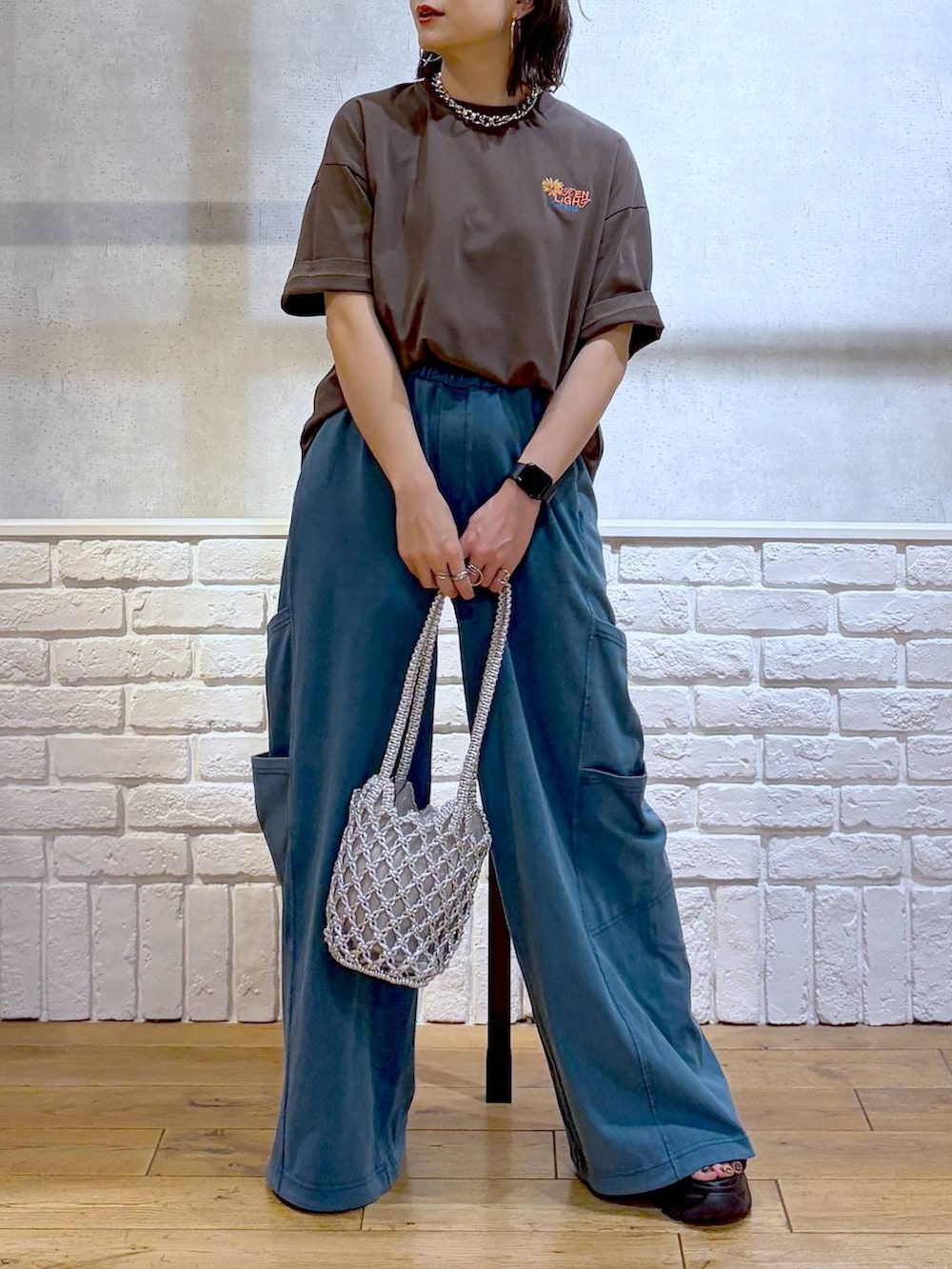シルバー系のショルダーバッグ、ブラック系のサンダル、ブラウン系のTシャツ/カットソーを着用したレディースの春コーディネートの3枚目の写真