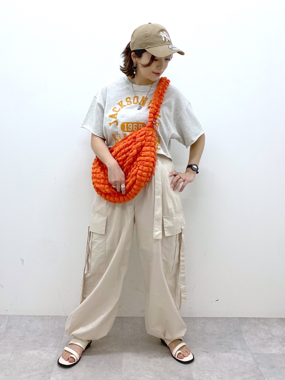 ホワイト系のカーゴパンツ、ホワイト系のサンダル、ベージュ系のTシャツ/カットソーを着用したレディースの春コーディネートの5枚目の写真