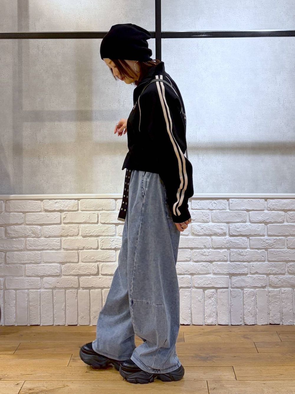 ブラック系のスニーカー、グレー系のショルダーバッグ、ブルー系のデニムパンツを着用したレディースの春コーディネートの7枚目の写真