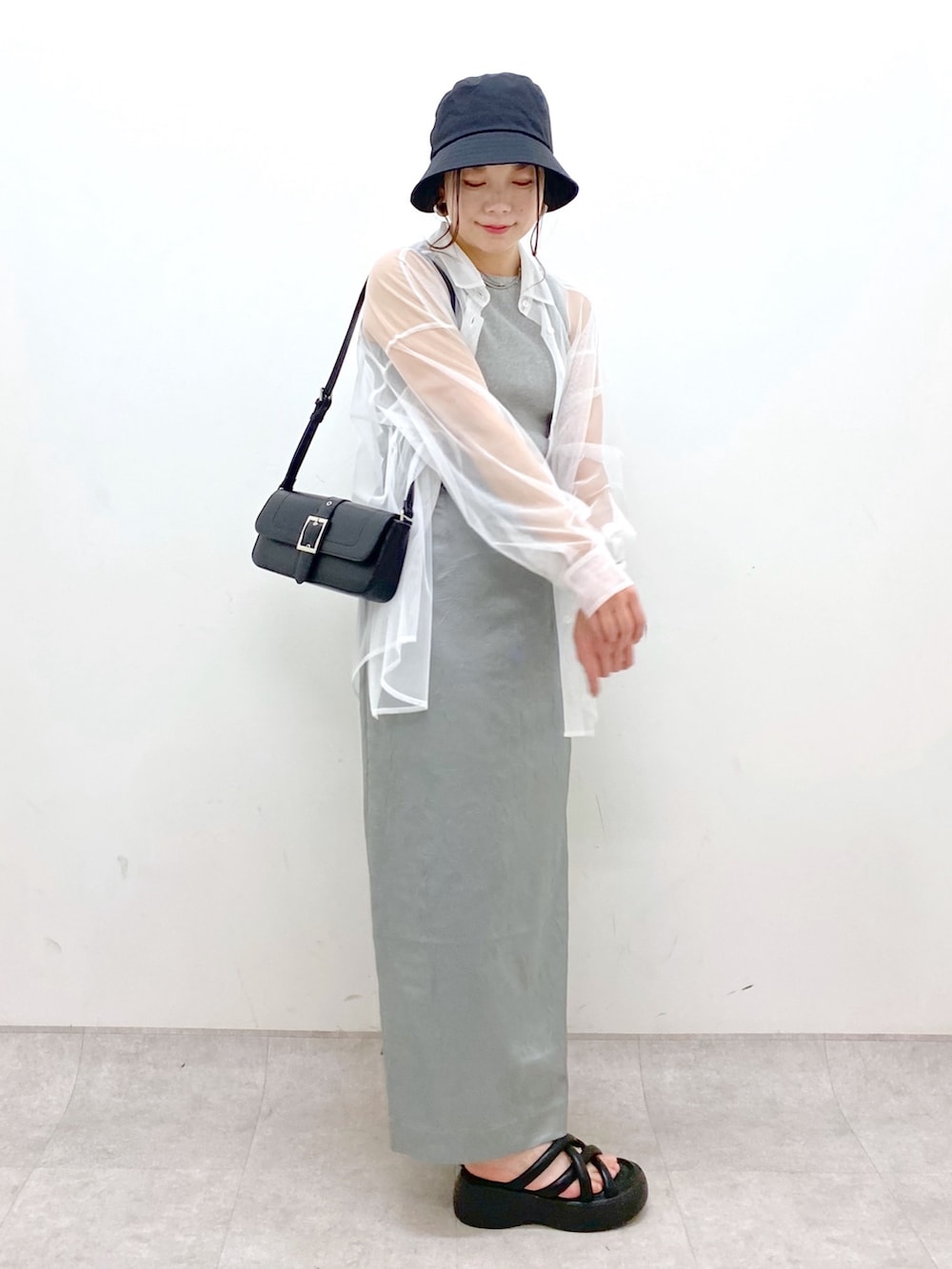 ブルー系のスカート、ブラック系のハンドバッグ、ブラック系のサンダルを着用したレディースの春コーディネートの7枚目の写真