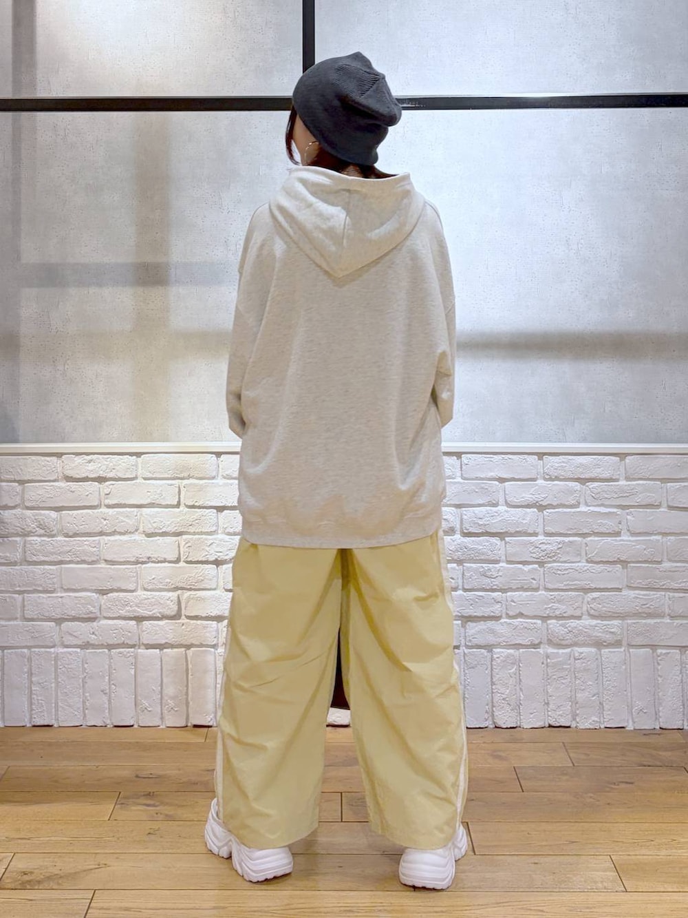 ホワイト系のスニーカー、イエロー系のスウェットパンツ、ブラウン系のショルダーバッグを着用したレディースの春コーディネートの6枚目の写真