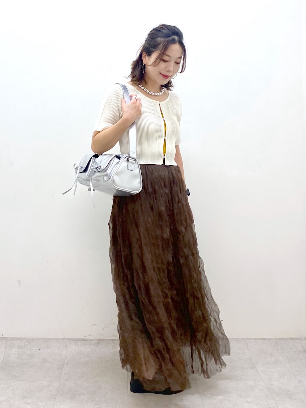 ブラウン系のスカート、ブラック系のサンダル、シルバー系のショルダーバッグを着用したレディースの夏コーディネートの5枚目の写真