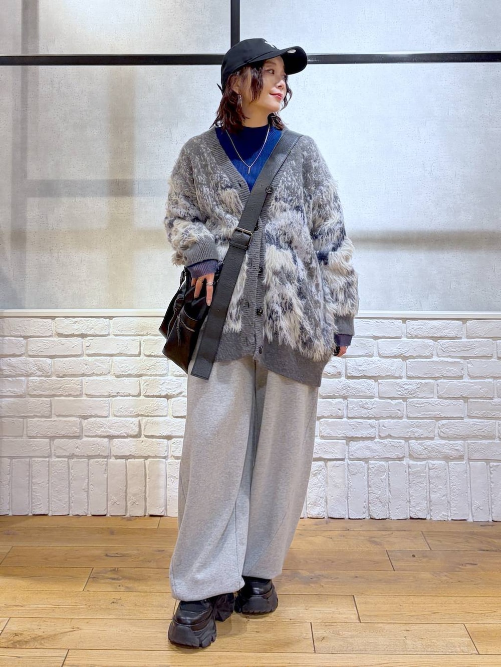 ブラック系のブーツ、グレー系のスウェットパンツ、ブラック系のボストンバッグを着用したレディースの冬コーディネートの8枚目の写真