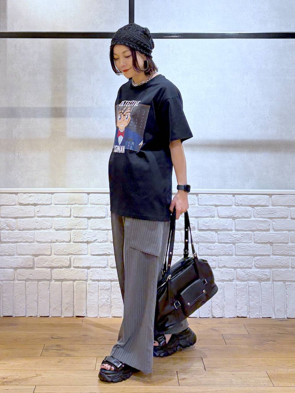 ブラック系のサンダル、ブラック系のボストンバッグ、ブラック系のTシャツ/カットソーを着用したレディースの春コーディネートの5枚目の写真