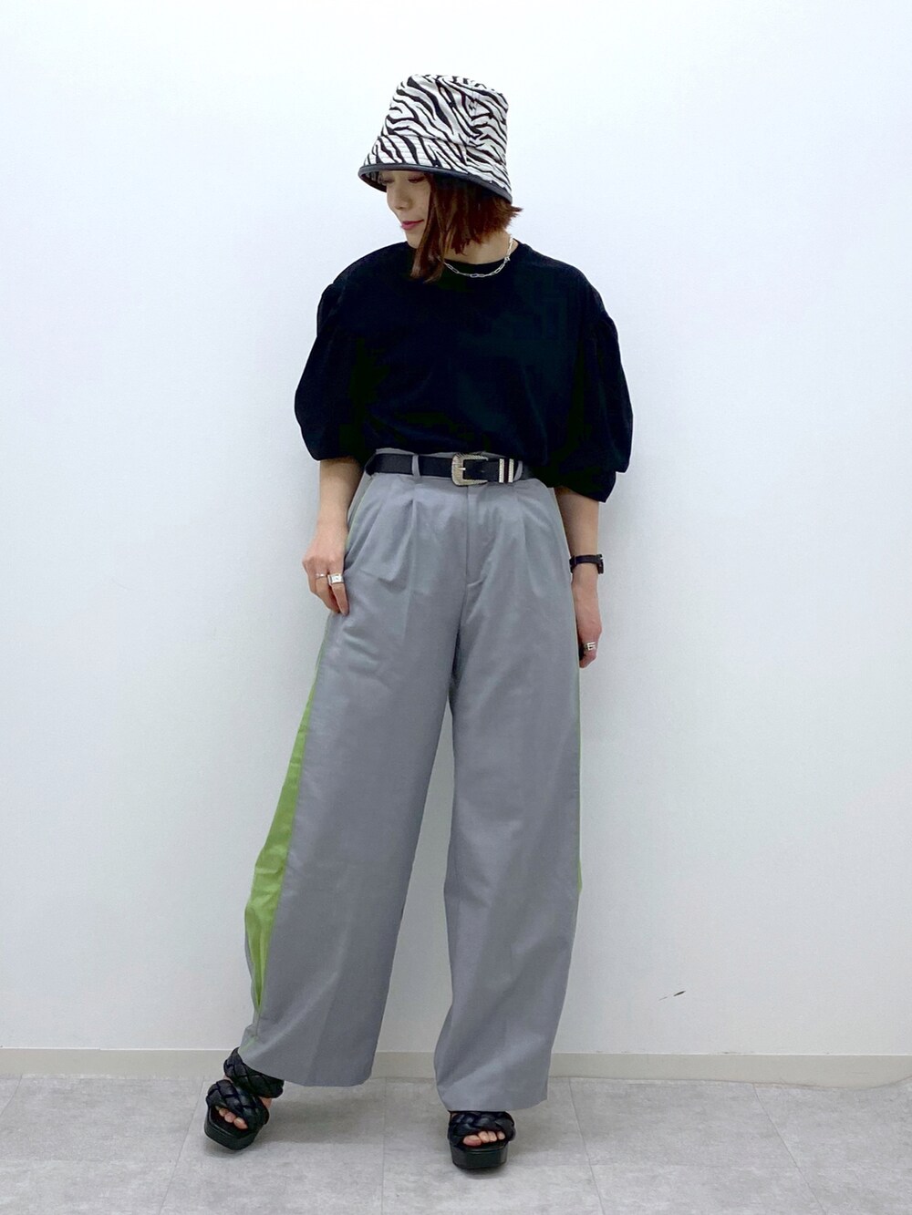 ブラック系のTシャツ/カットソー、グレー系のスラックス、ブラック系のサンダルを着用したレディースの春コーディネートの2枚目の写真