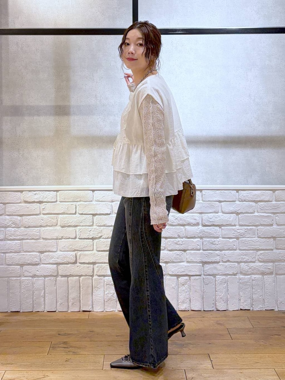 ブルー系のデニムパンツ、ブラウン系のボストンバッグ、ブラウン系のサンダルを着用したレディースの春コーディネートの7枚目の写真