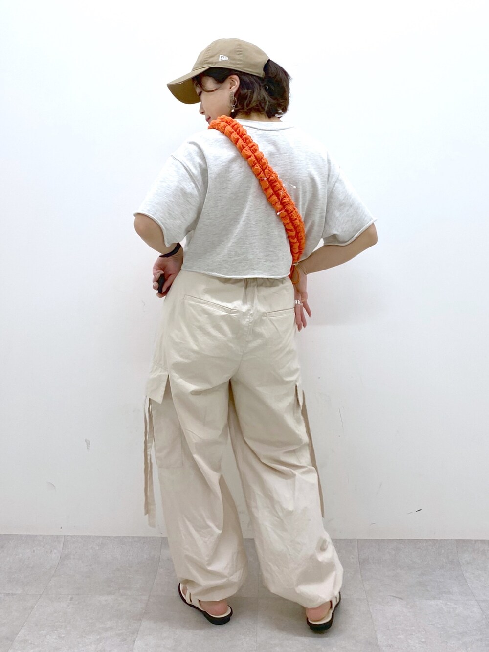 ホワイト系のカーゴパンツ、ホワイト系のサンダル、ベージュ系のTシャツ/カットソーを着用したレディースの春コーディネートの3枚目の写真