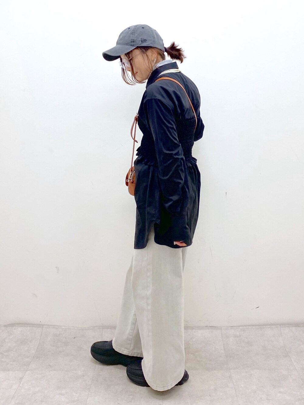 ブラック系のシャツ/ブラウス、ベージュ系のショルダーバッグ、グレー系のデニムパンツを着用したレディースの冬コーディネートの7枚目の写真