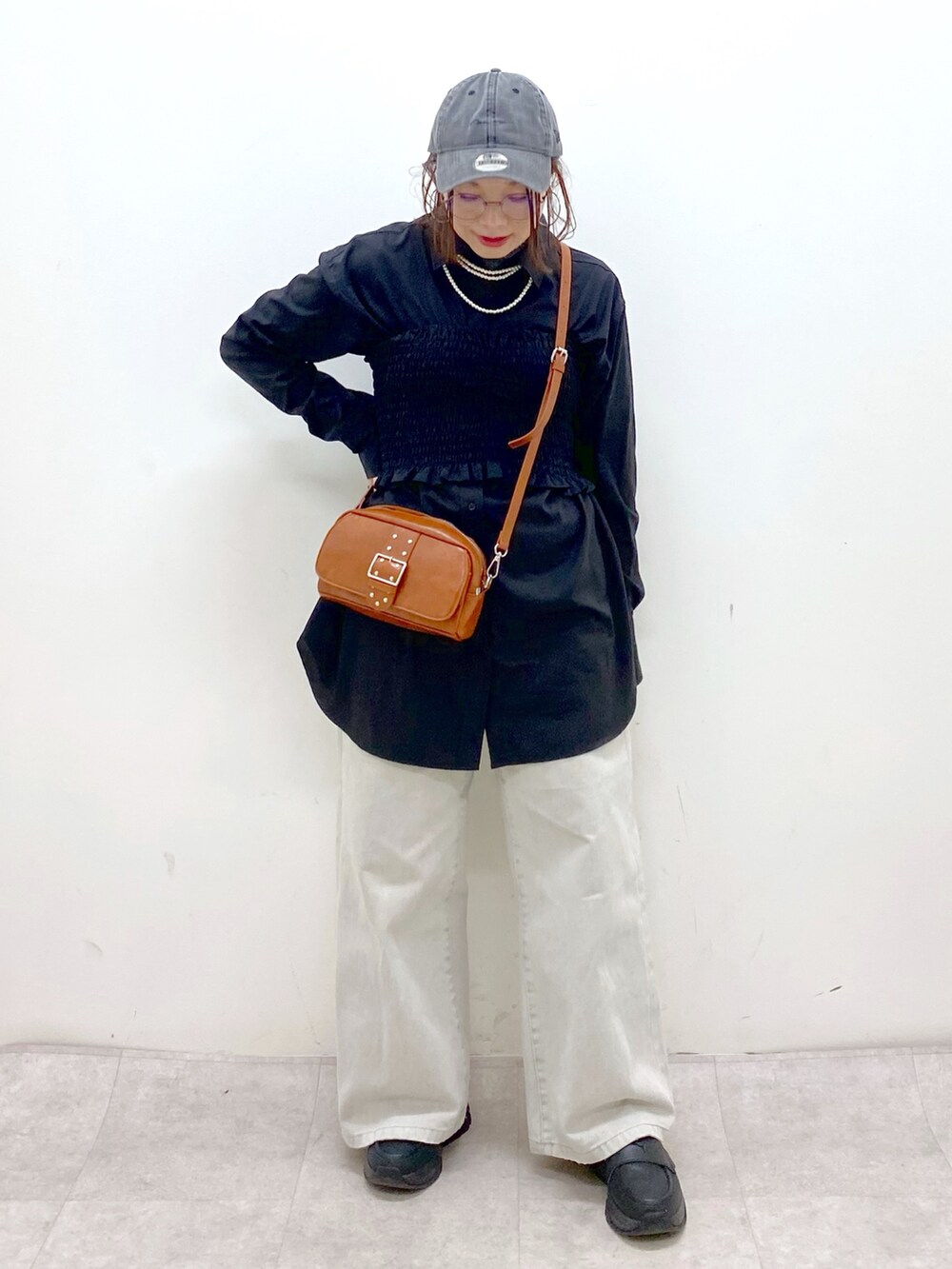 ブラック系のシャツ/ブラウス、ベージュ系のショルダーバッグ、グレー系のデニムパンツを着用したレディースの冬コーディネートの8枚目の写真