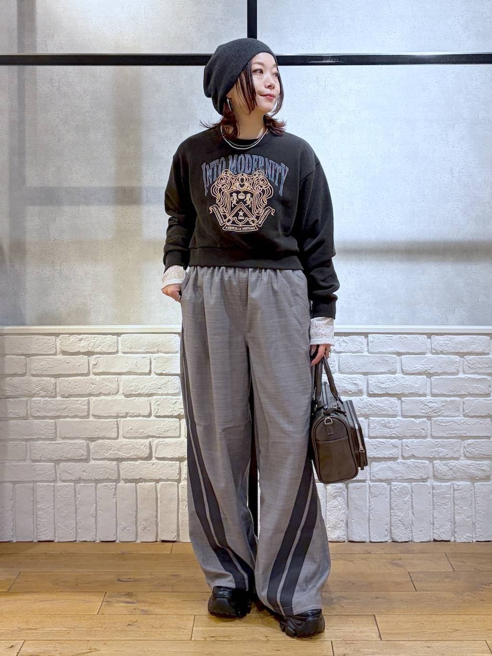 ブラック系のスニーカー、グレー系のスウェット、ブラック系のショルダーバッグを着用したレディースの冬コーディネートの8枚目の写真