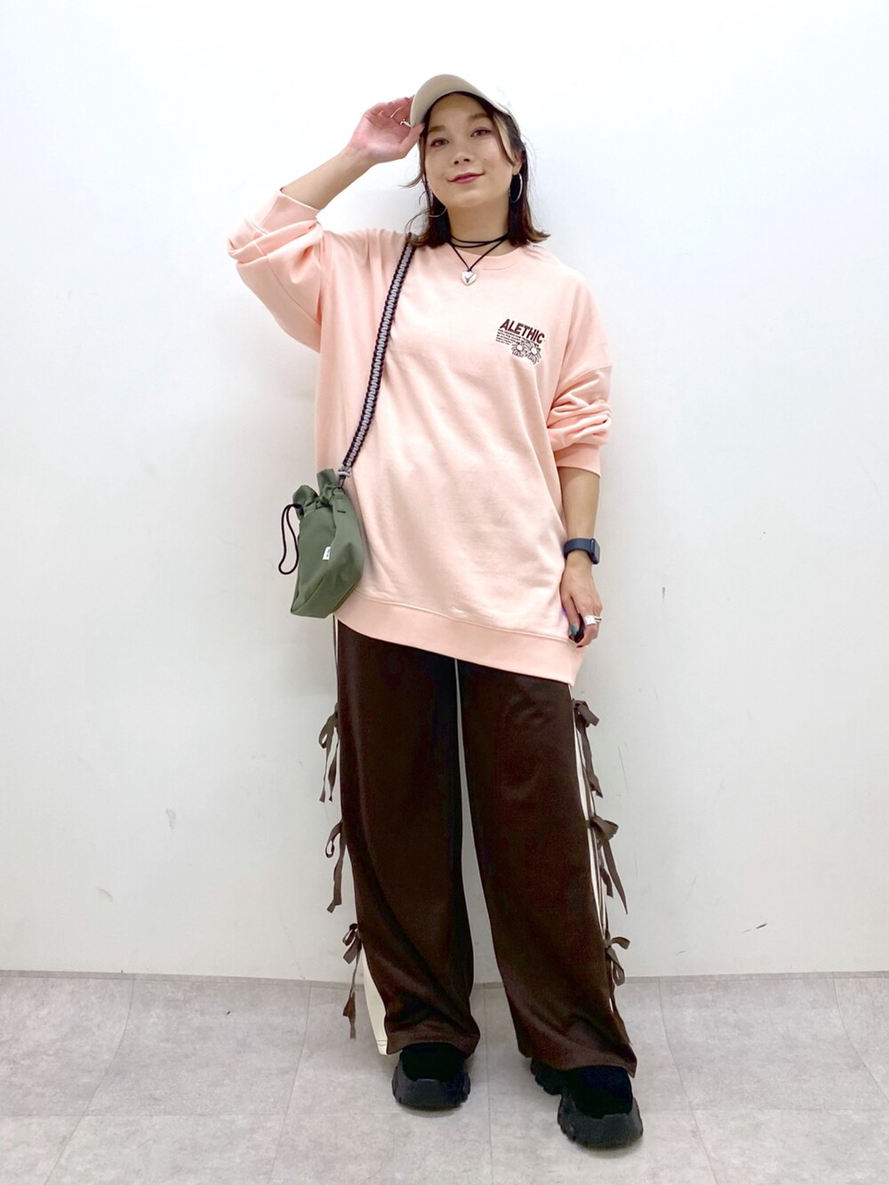 ピンク系のスウェット、グリーン系のショルダーバッグ、ブラウン系のその他パンツを着用したレディースの夏コーディネートの4枚目の写真