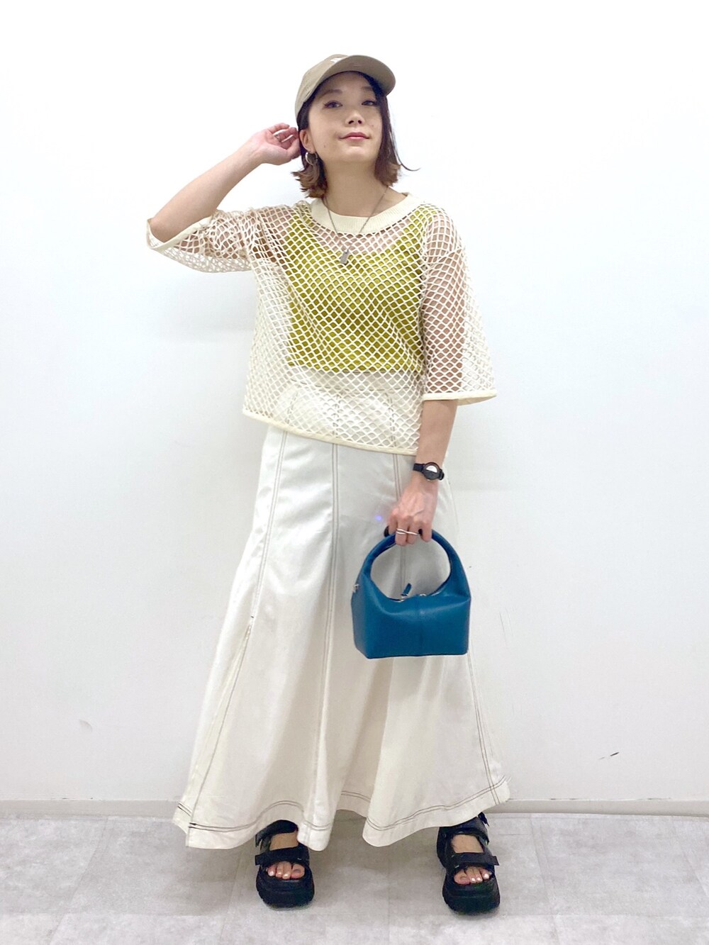 ホワイト系のスカート、ブラック系のサンダル、ブルー系のショルダーバッグを着用したレディースの夏コーディネートの5枚目の写真