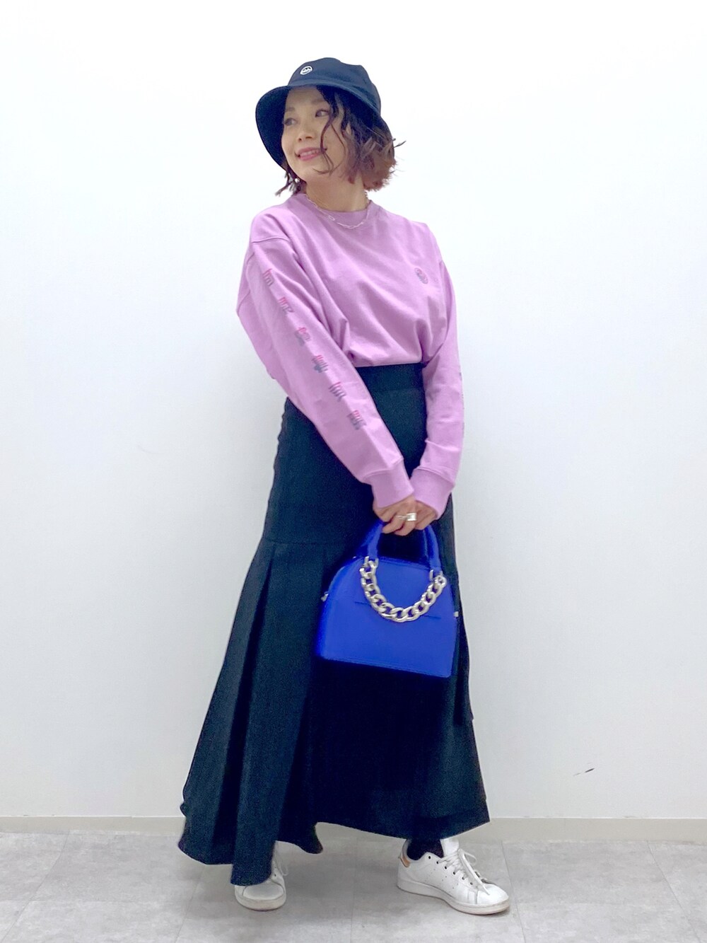 ピンク系のTシャツ/カットソー、ブラック系のスカート、ブルー系のショルダーバッグを着用したレディースの春コーディネートの2枚目の写真