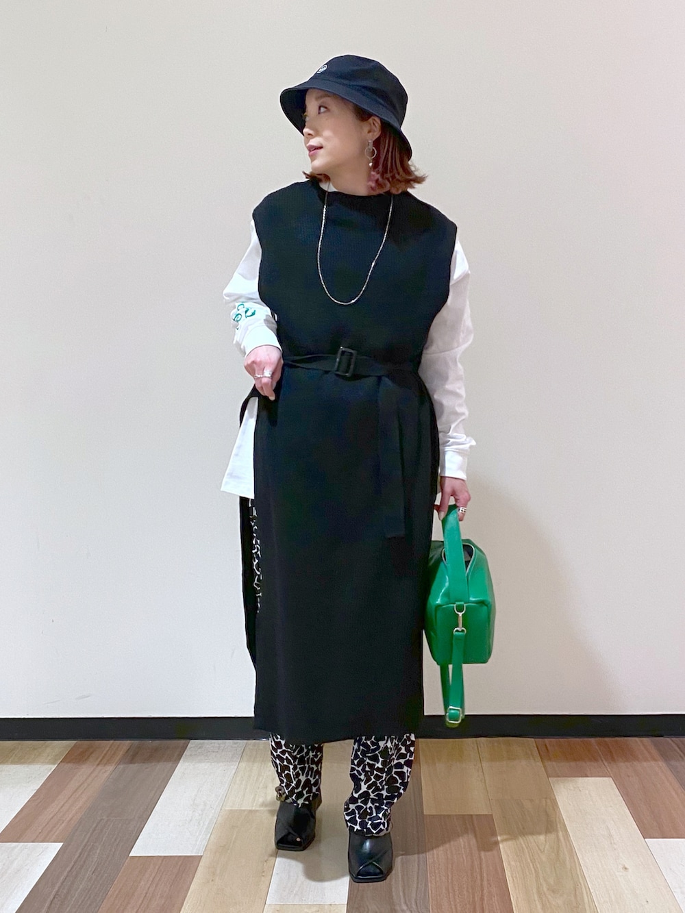 ブラック系のパンプス、ブラック系のワンピース、ホワイト系のTシャツ/カットソーを着用したレディースの冬コーディネートの2枚目の写真