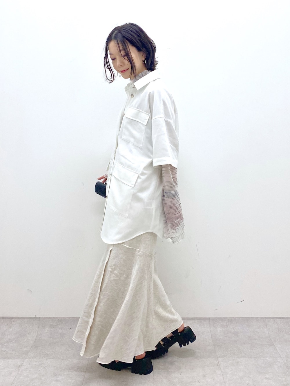 ホワイト系のトップス、ホワイト系のトップス、ブラック系のバッグを着用したレディースの春コーディネートの3枚目の写真