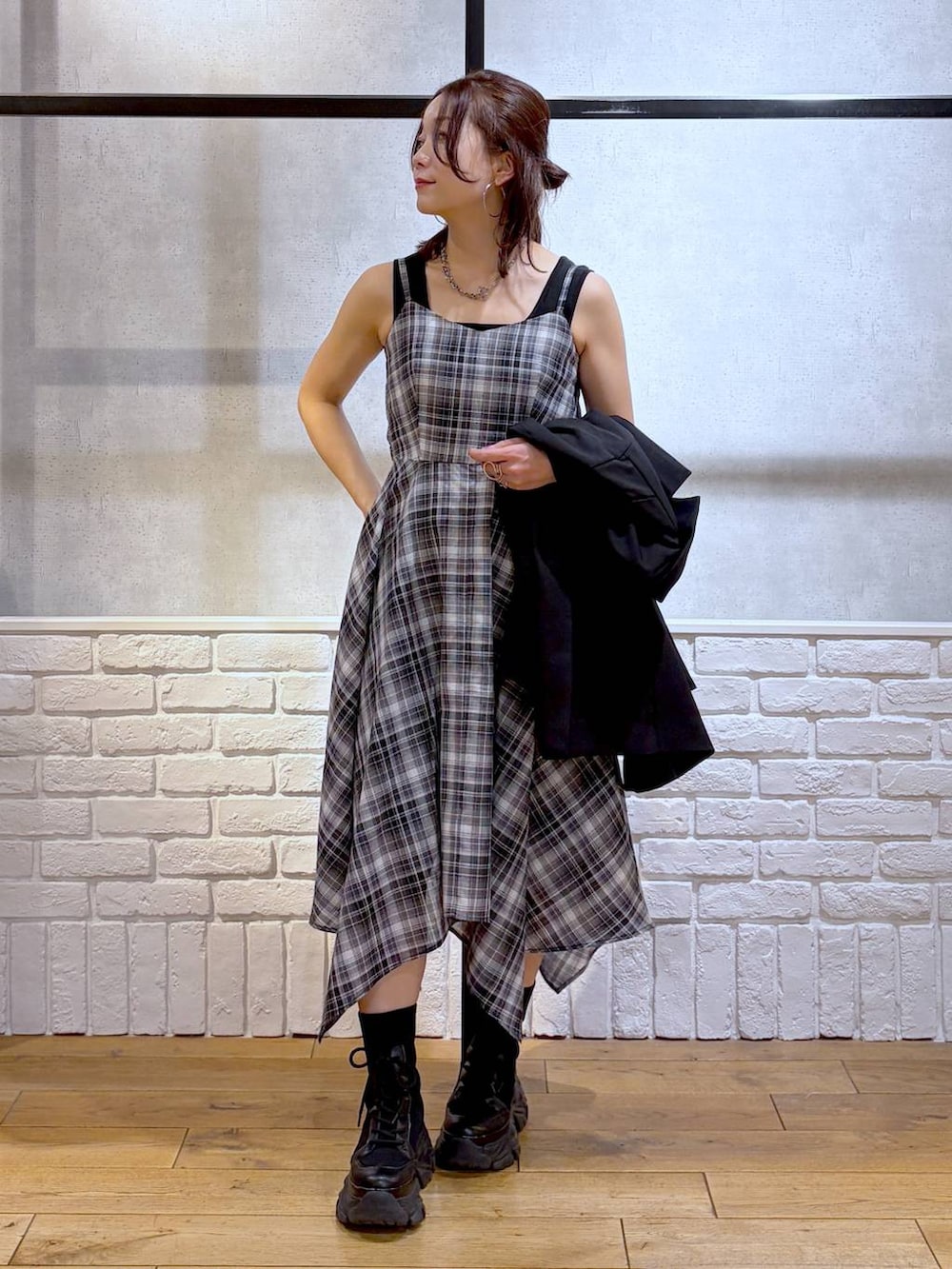 ブラック系のブーツ、ブラック系のハンドバッグ、ブラック系のテーラードジャケットを着用したレディースの春コーディネートの4枚目の写真