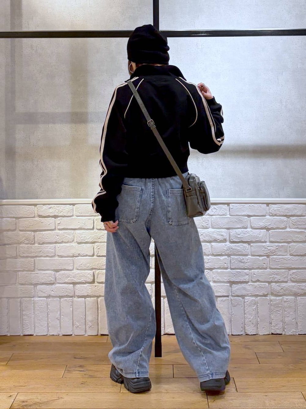 ブラック系のスニーカー、グレー系のショルダーバッグ、ブルー系のデニムパンツを着用したレディースの春コーディネートの6枚目の写真