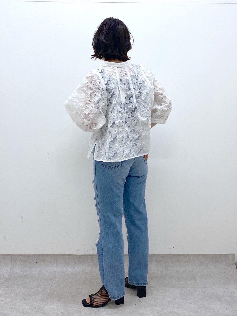 ブルー系のパンツ、ホワイト系のシャツ/ブラウス、ブラック系のトップスを着用したレディースの春コーディネートの3枚目の写真