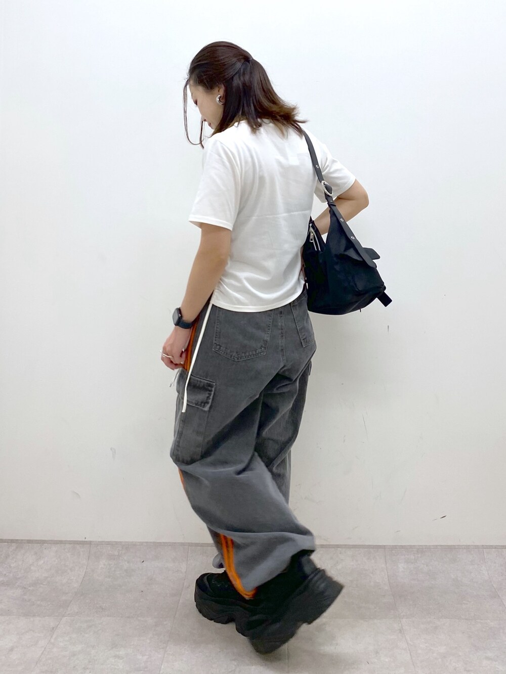 ホワイト系のTシャツ/カットソー、ブラック系のデニムパンツ、ブラック系のスニーカーを着用したレディースの春コーディネートの5枚目の写真