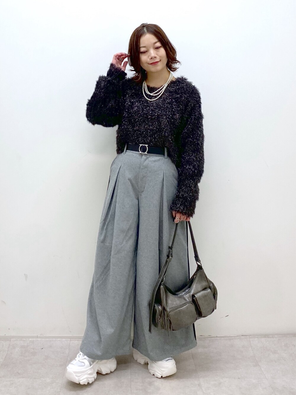 ブラック系のニット/セーター、ブラック系のスラックス、その他のショルダーバッグを着用したレディースの冬コーディネートの8枚目の写真