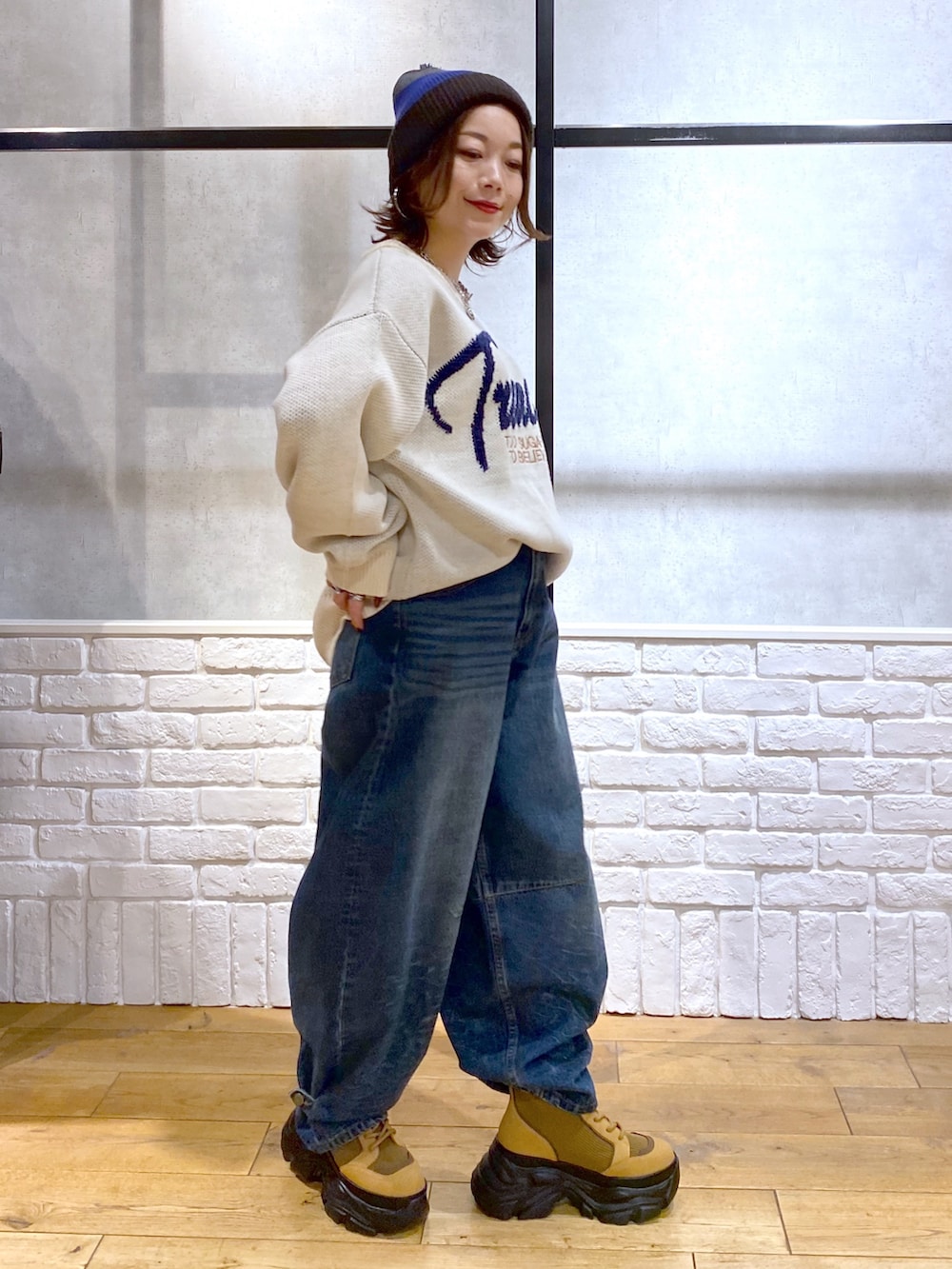 ホワイト系のニット/セーター、ブルー系のデニムパンツ、ブラウン系のブーツを着用したレディースの冬コーディネートの5枚目の写真