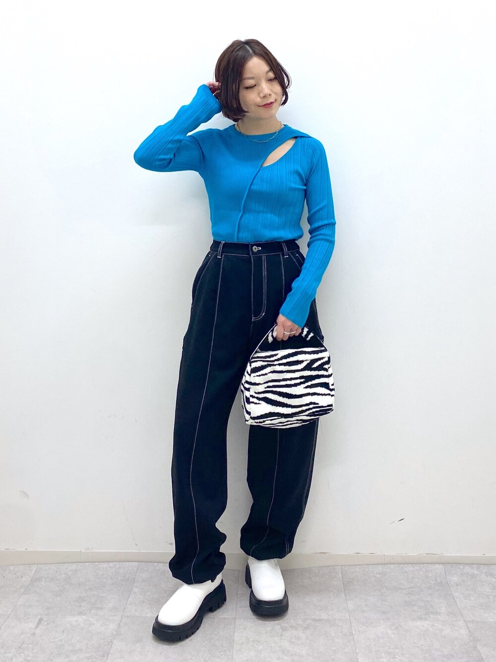 ブラック系のパンツ、ブラック系のバッグ、ホワイト系のシューズを着用したレディースの秋コーディネートの2枚目の写真