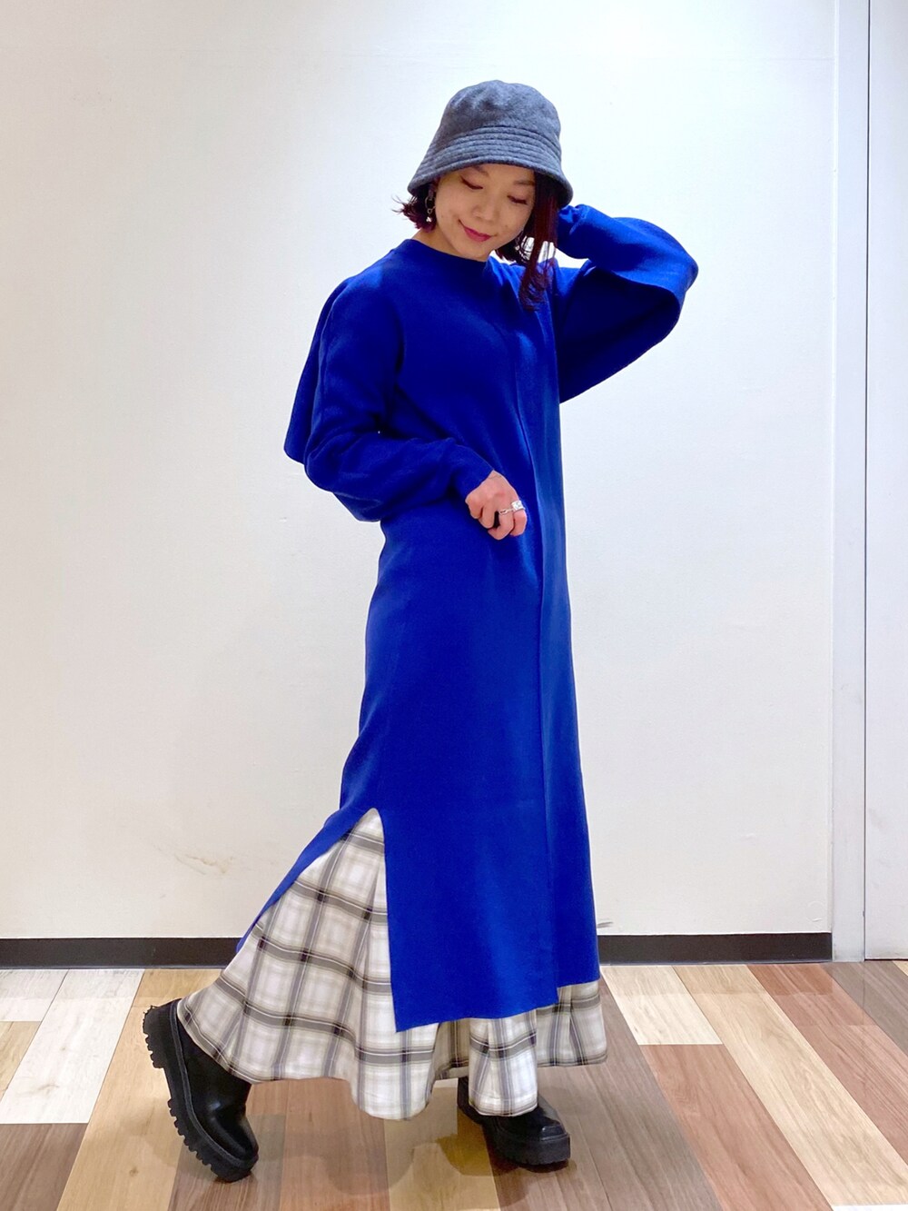 ブルー系のワンピース、ブラック系のブーツ、ホワイト系のスカートを着用したレディースの冬コーディネートの5枚目の写真