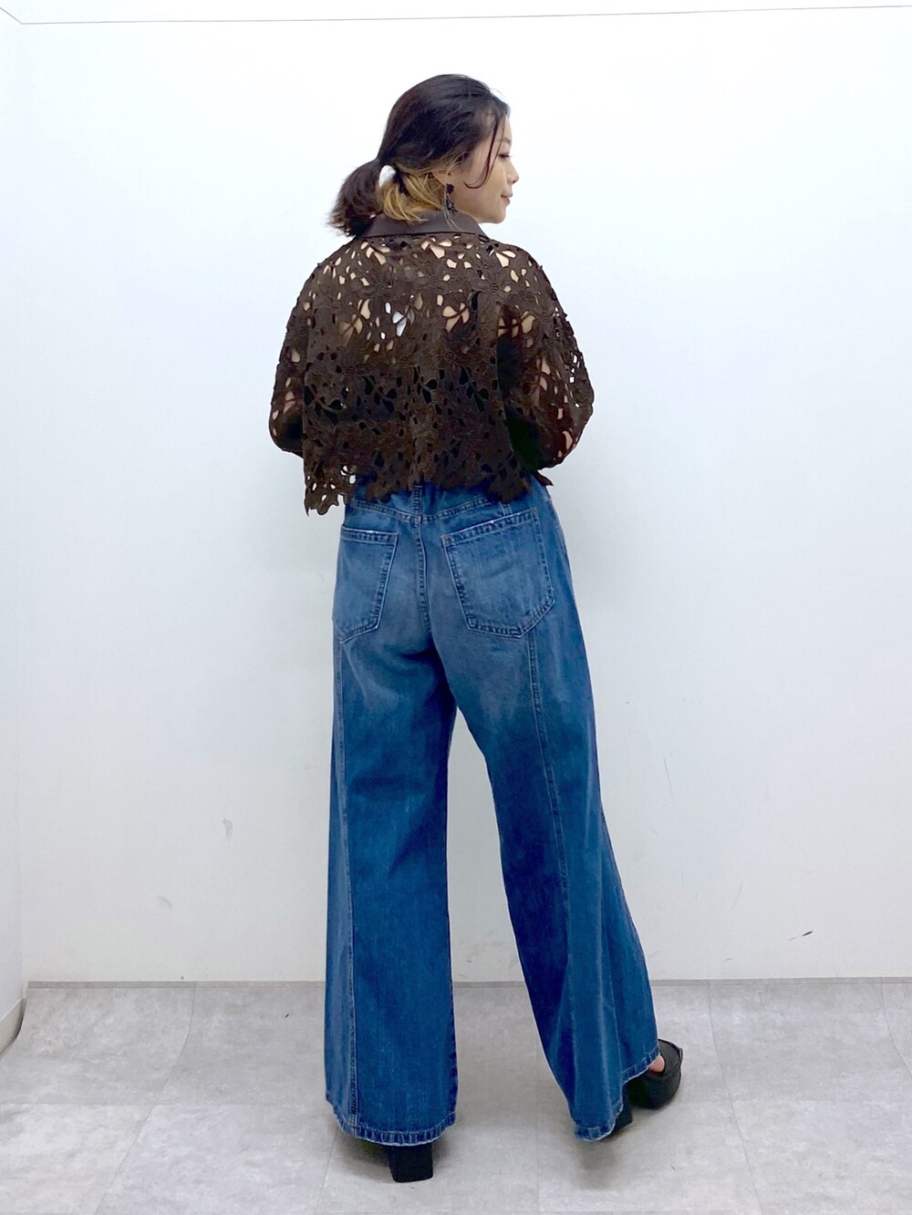 ブルー系のデニムパンツ、ブラウン系のカーディガン/ボレロ、ブラック系のキャミソールを着用したレディースの夏コーディネートの5枚目の写真