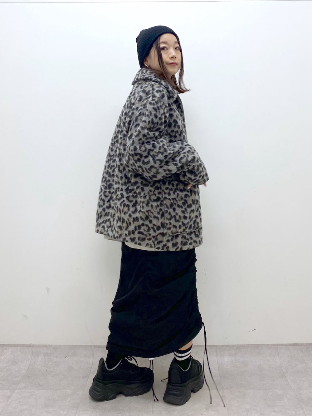 ベージュ系のスウェット、ブラック系のワンピース、ブラック系のスニーカーを着用したレディースの冬コーディネートの3枚目の写真