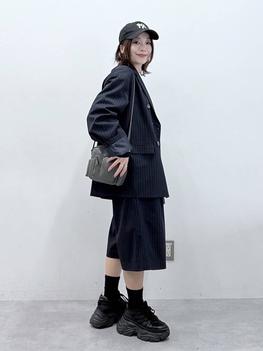 ブラック系のスニーカー、グレー系のショルダーバッグ、ブラック系のTシャツ/カットソーを着用したレディースの春コーディネートの5枚目の写真