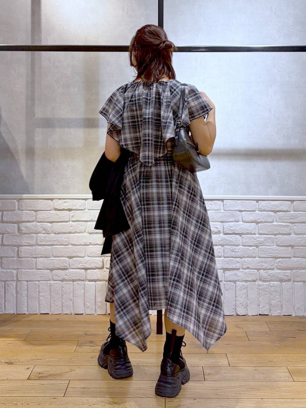 ブラック系のブーツ、ブラック系のハンドバッグ、ブラック系のテーラードジャケットを着用したレディースの春コーディネートの3枚目の写真