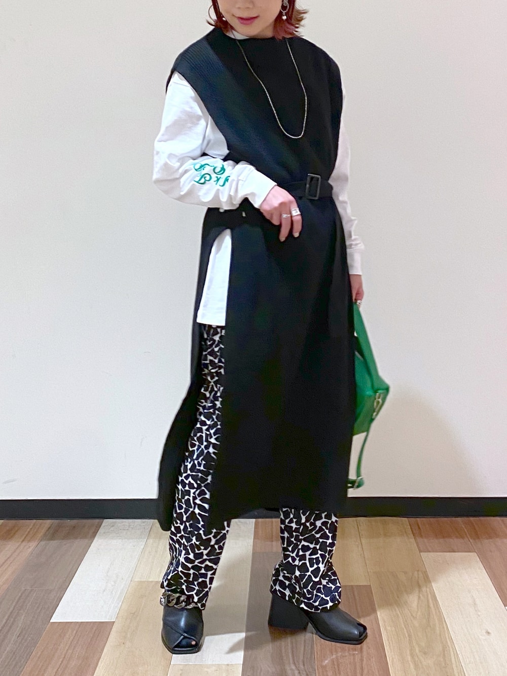 ブラック系のパンプス、ブラック系のワンピース、ホワイト系のTシャツ/カットソーを着用したレディースの冬コーディネートの5枚目の写真