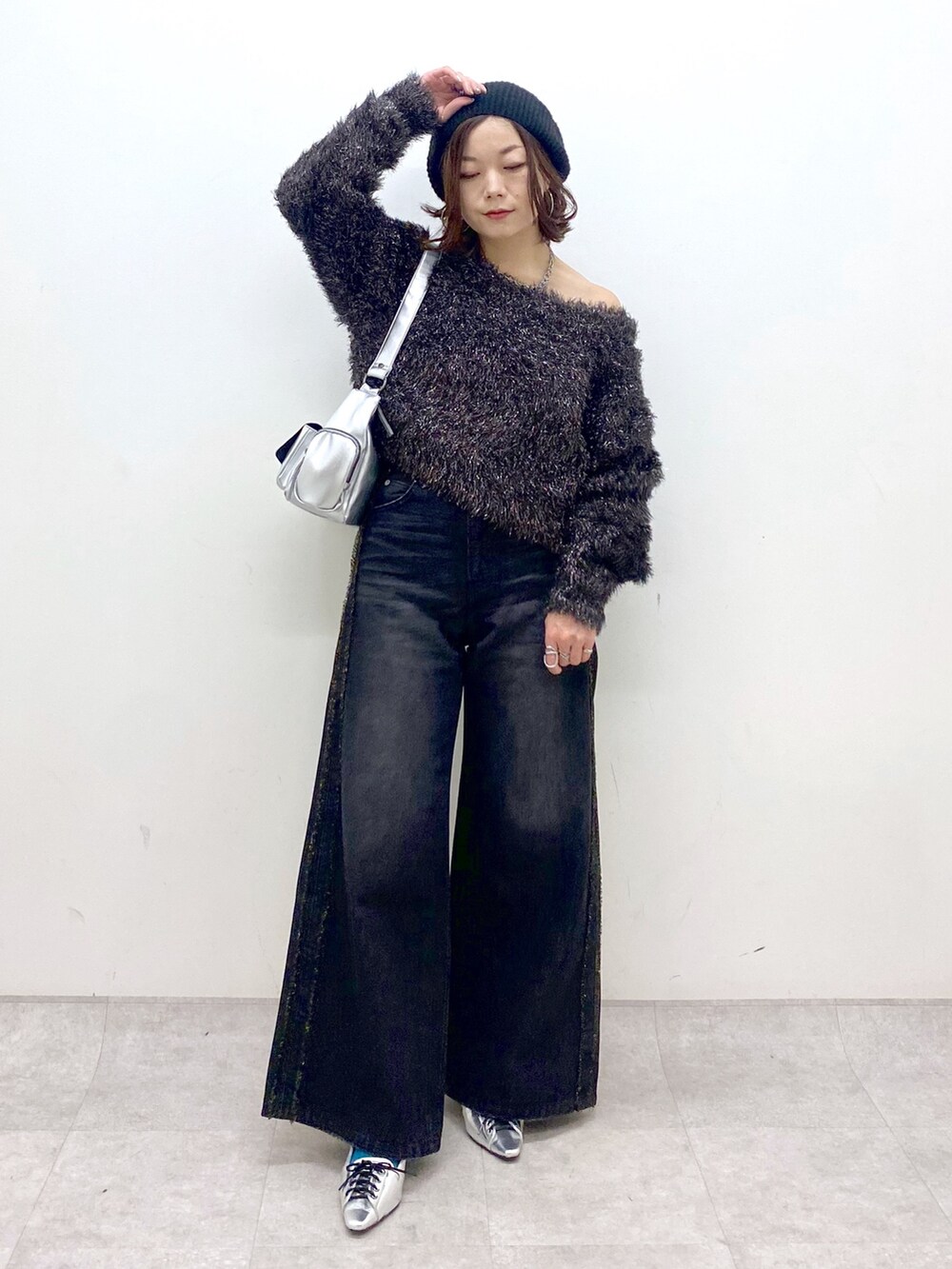 ブラック系のデニムパンツ、シルバー系のパンプス、シルバー系のショルダーバッグを着用したレディースの秋コーディネートの8枚目の写真