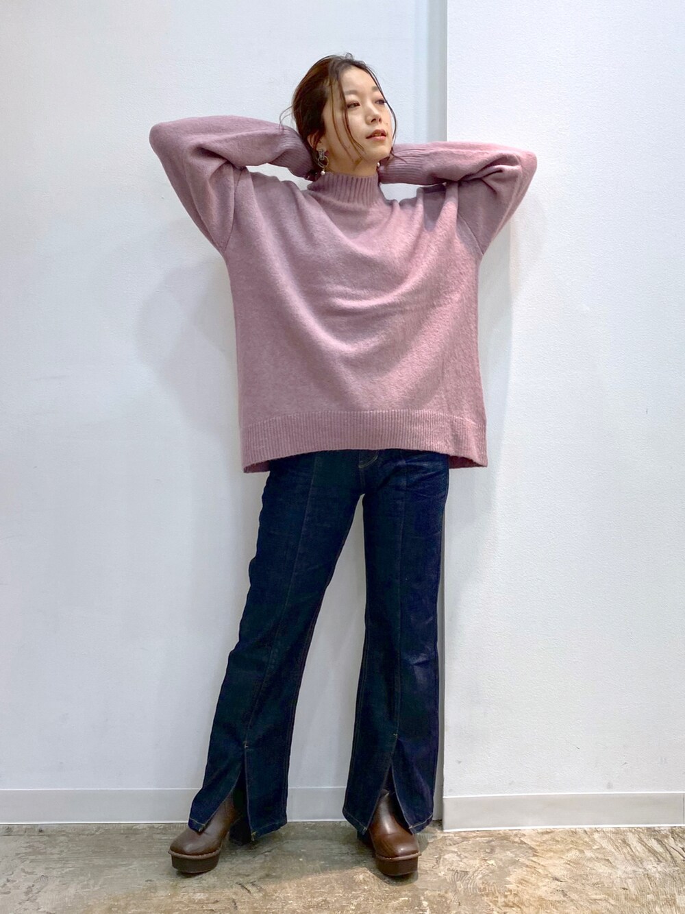 ピンク系のニット/セーター、ブルー系のデニムパンツ、ブラウン系のブーツを着用したレディースの秋コーディネートの5枚目の写真