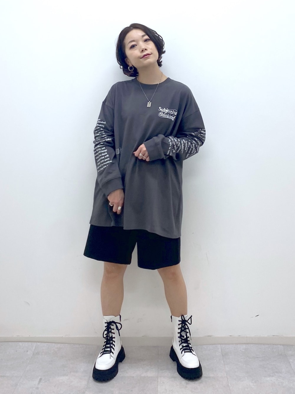 グレー系のTシャツ/カットソー、ブラック系のパンツ、ホワイト系のジャケット/アウターを着用したレディースの秋コーディネートの4枚目の写真