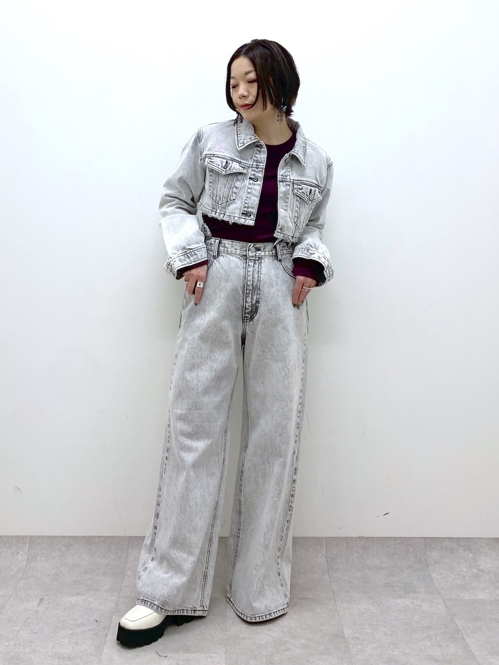 グレー系のデニムパンツ、グレー系のデニムジャケット、レッド系のTシャツ/カットソーを着用したレディースの冬コーディネートの5枚目の写真